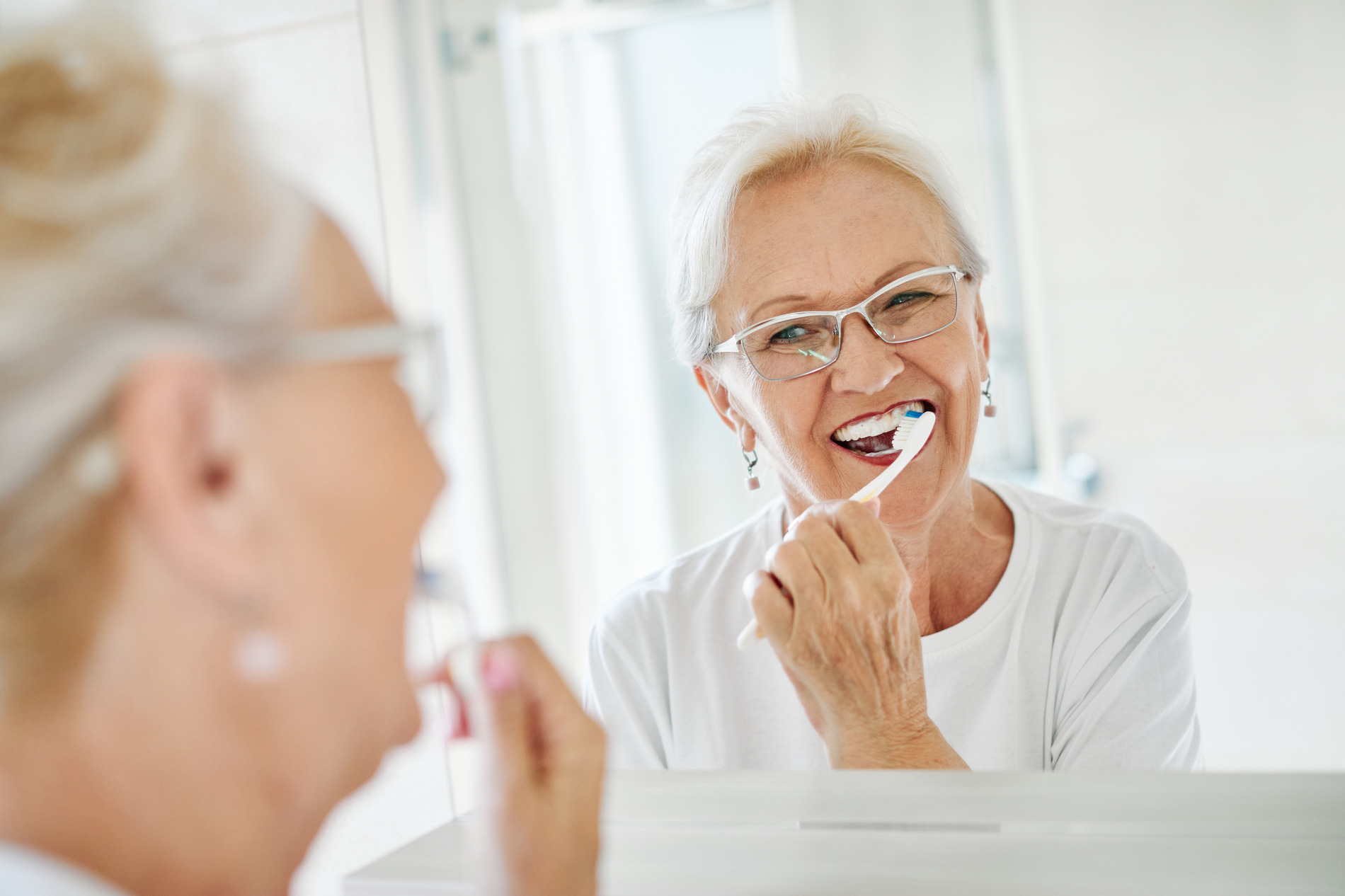 Woman brushing her teeth in Vero BEach FL