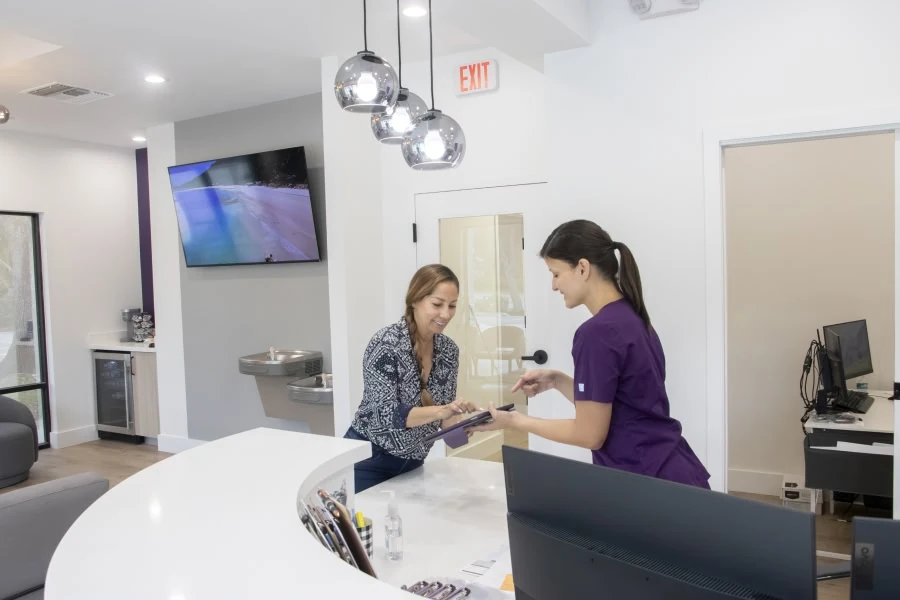 Team member helping a patient at the Novak Dental front desk in Vero Beach, FL