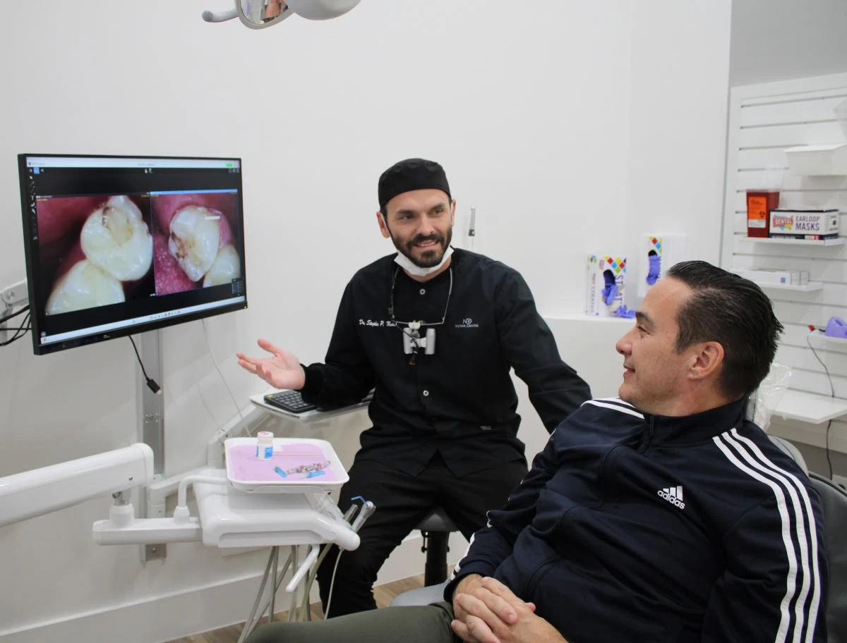 Dentist reviewing dental photos with a patient at Novak Dental in Vero Beach, FL