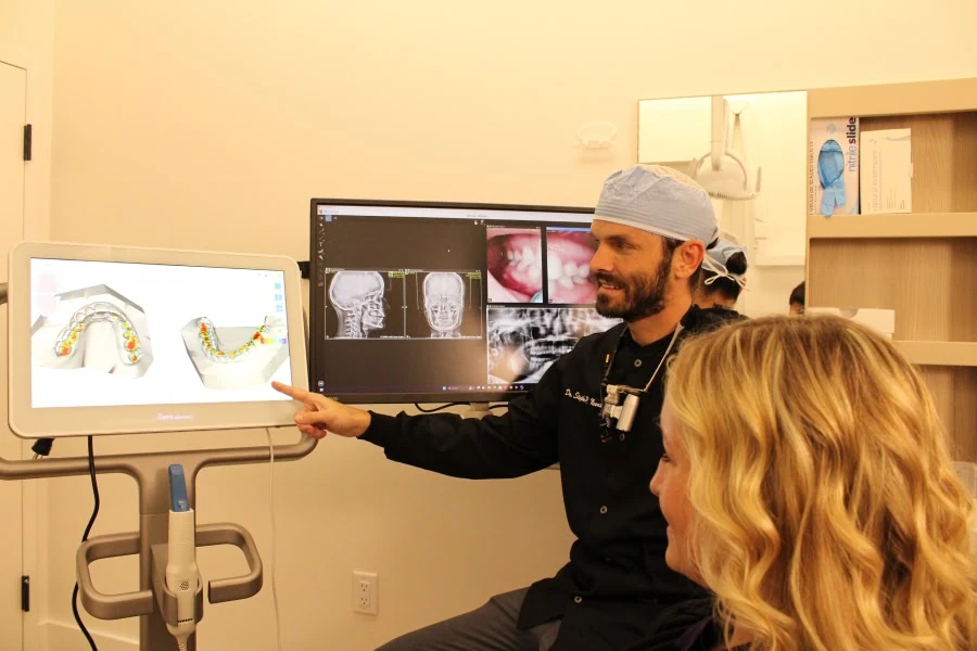 Dentist reviewing oral surgery scans with a patient in Vero Beach, FL