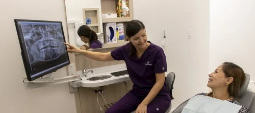 Dental team member explaining a panoramic X-ray to a new patient in Vero Beach, FL