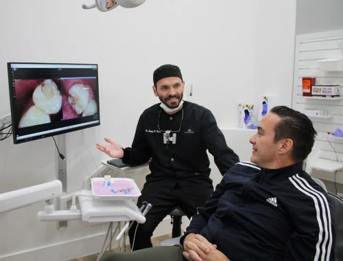 Dentist reviewing dental photos with a patient at Novak Dental in Vero Beach, FL